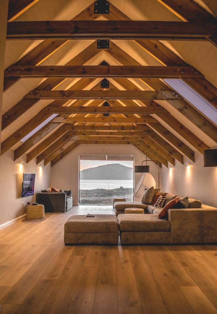 Attic loft with exposed wood beams and a sunset view