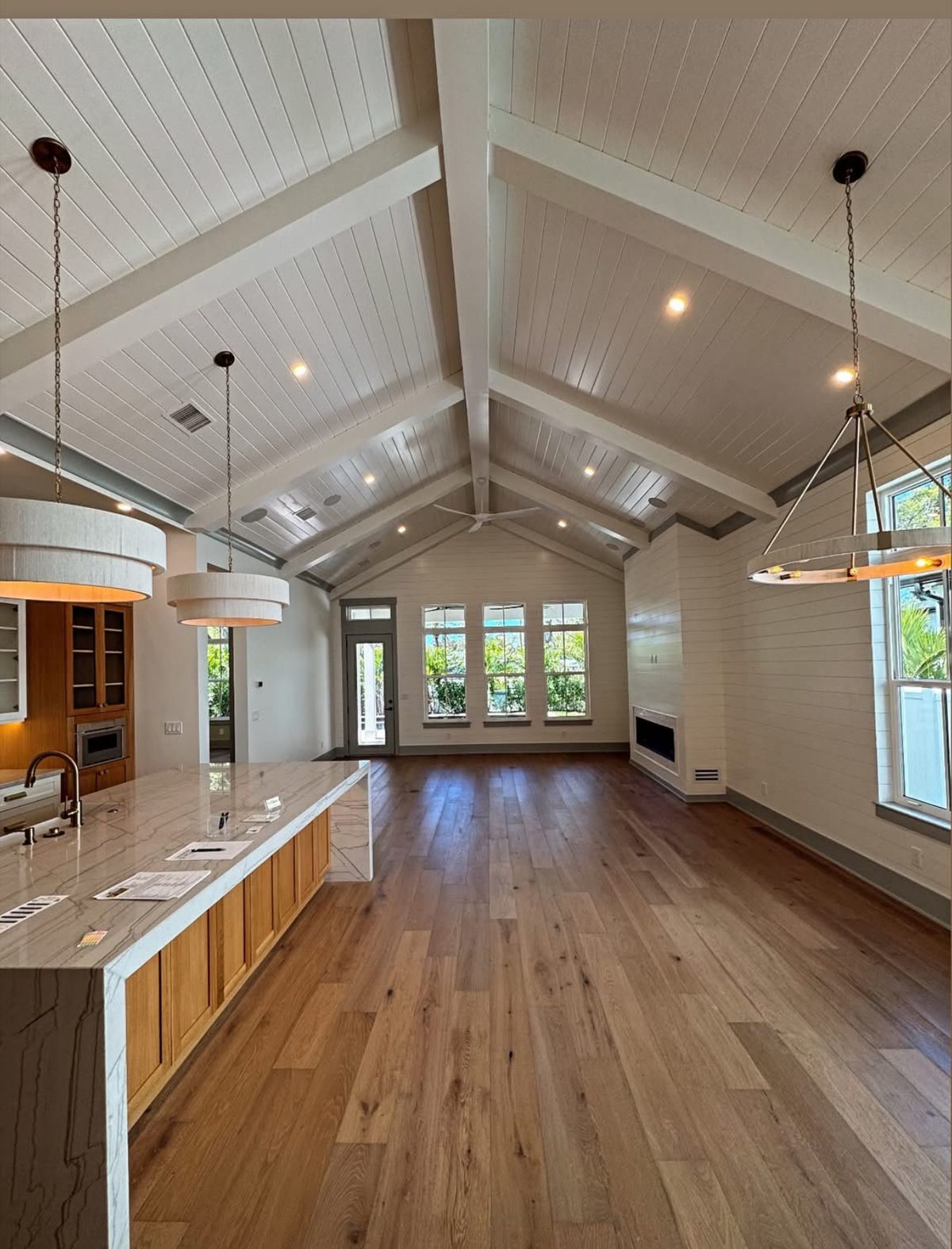 Vaulted white great room opening to a kitchen island