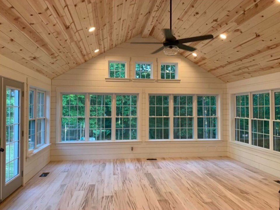 Sunroom with a pine ceiling and a wall of windows
