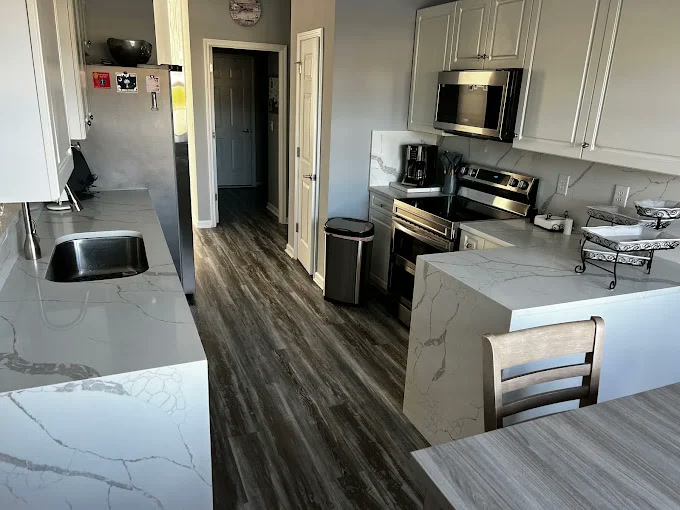 Kitchen with white quartz island and wood floors