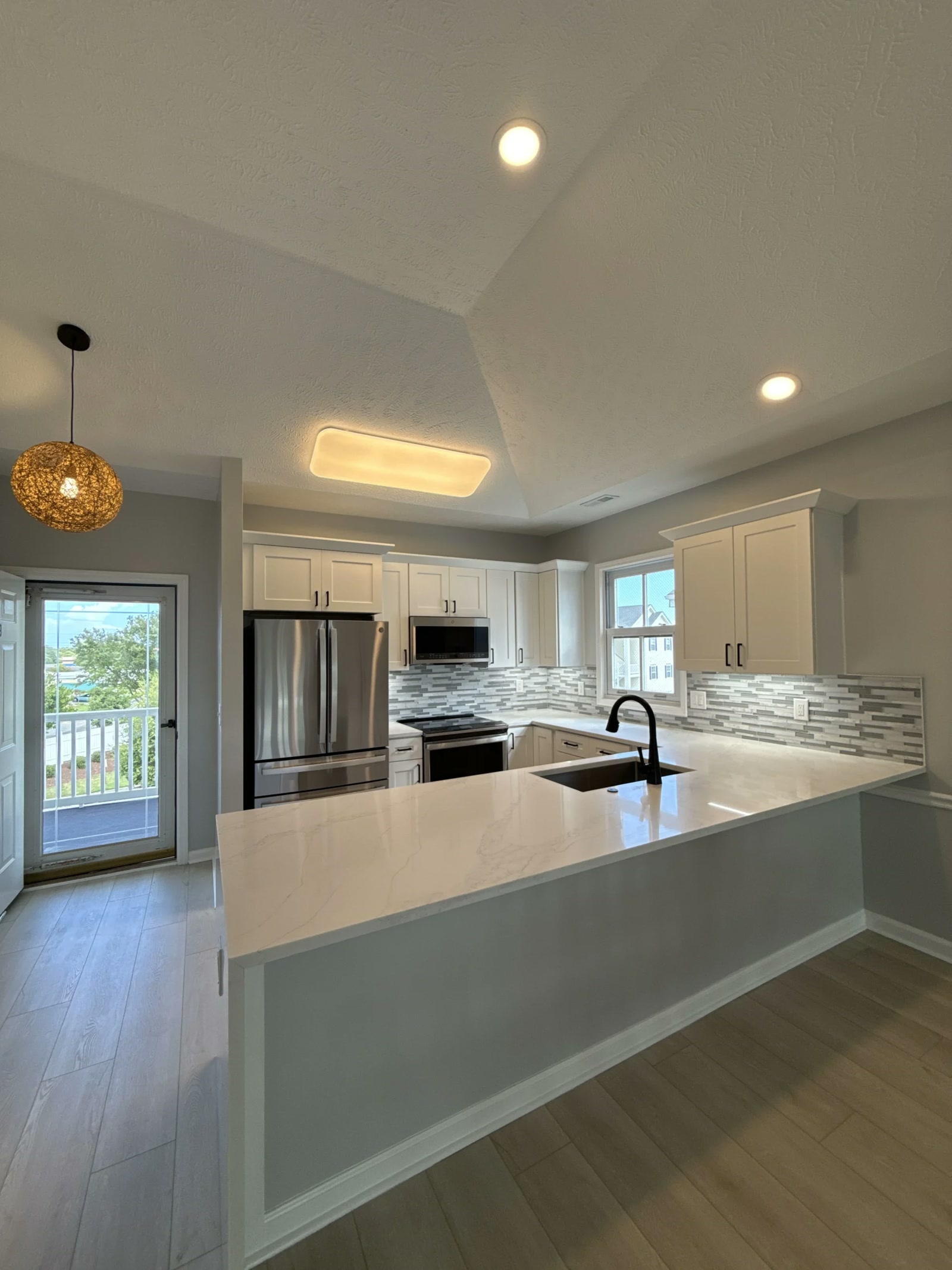 Bright kitchen with white island and stainless appliances